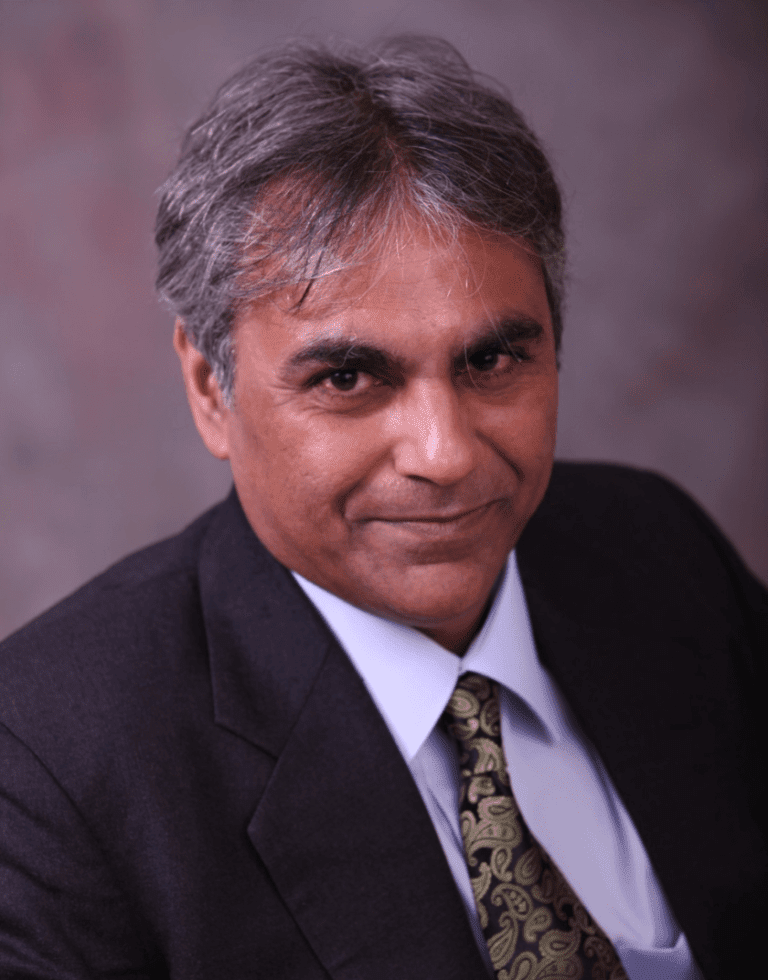 A professional man named Vinay D. Dwarkadas wearing a black colored suit, and a tie.